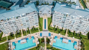 A symmetrical hotel complex with two main buildings, a central pool, and surrounding greenery. - 3 bdrm/2 bath Villa w/pool, Azure Beach Residences (Oranjestad-West)