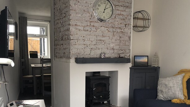 Ein Wohnzimmer mit Kamin, einer Couch, einem Couchtisch und einem Teppich.