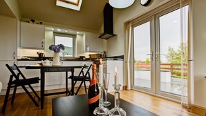 Una cocina moderna con una mesa de comedor, sillas y una botella de champán.