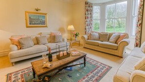 A cozy living room with two sofas, a coffee table, and a framed picture on the wall.