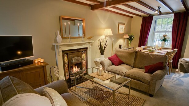 Una sala de estar acogedora con chimenea, televisor y asientos cómodos.