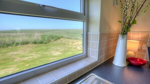 Una cocina con ventana que da a un campo cubierto de hierba.