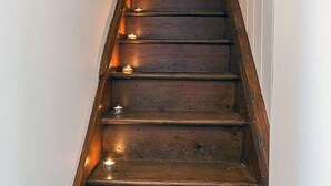 A wooden staircase with multiple steps and candles placed at intervals. - Coron -  a dog that sleeps 6 guests  in 3 bedrooms (Ty Croes)