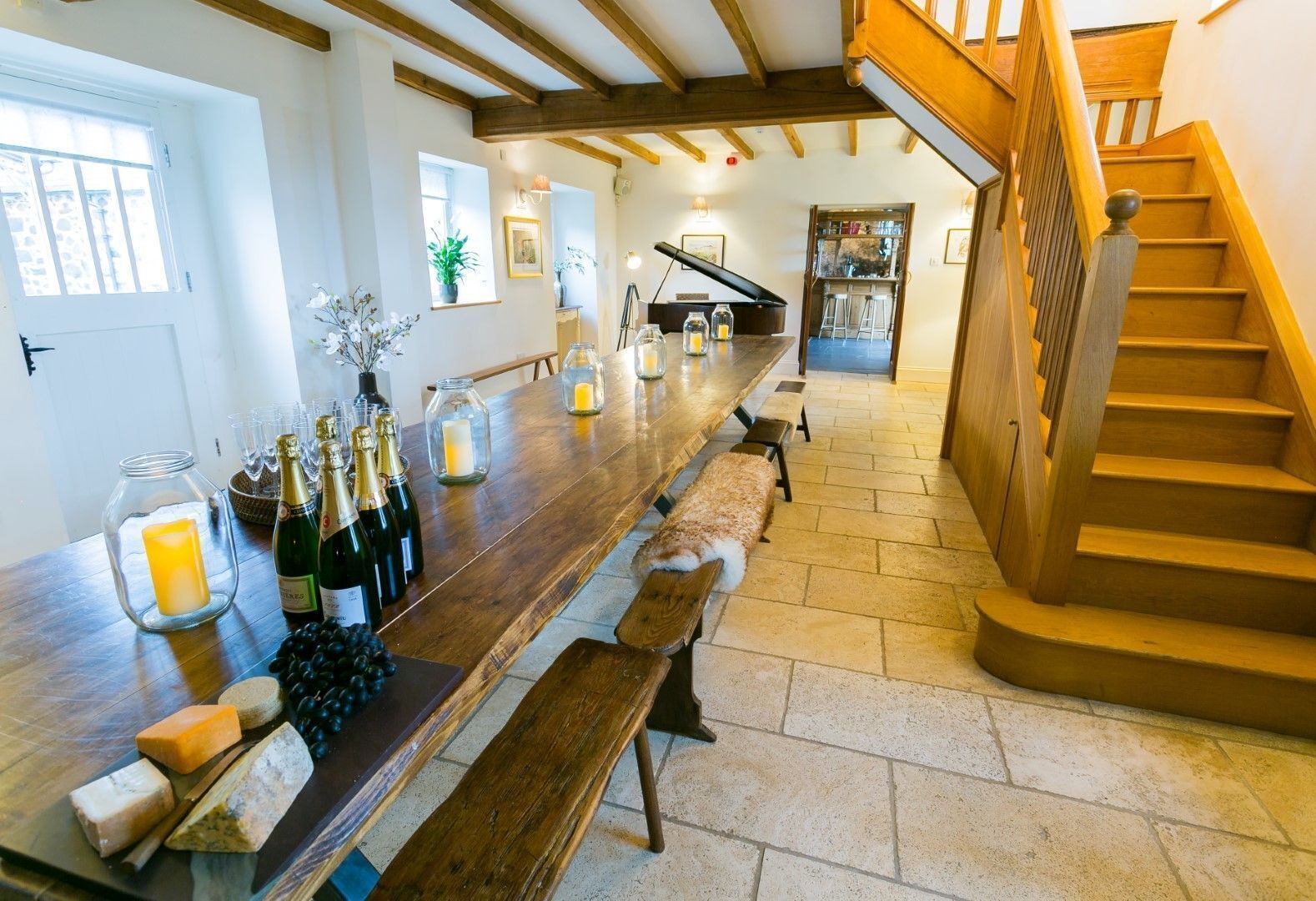 A spacious kitchen with a long wooden counter, a built-in wine rack, and a staircase leading to an upper level.