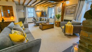 Ein gemütliches Wohnzimmer mit Kamin, einer Sofagarnitur und einem Couchtisch.