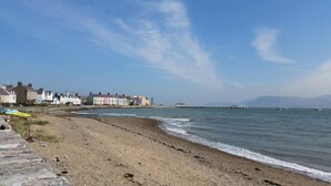 Una playa costera con una hilera de casas coloridas a lo largo de la orilla.