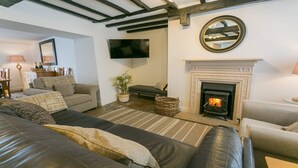Una sala de estar acogedora con chimenea, un televisor de pantalla plana y asientos cómodos.