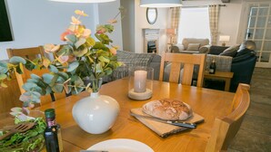 Una mesa de comedor con pan, una vela y un florero con flores.