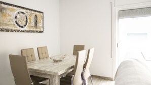 Un comedor con una mesa de madera y seis sillas, un cuenco decorativo sobre la mesa y una obra de arte en la pared.