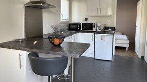 Cocina compacta equipada con estufa, microondas y cafetera.
