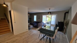 A spacious living area with a dining table, sofa, and a staircase leading to another level. - "Charming 3-Bedroom Cottage with Jacuzzi, Near Loire and Forest, Ouzouer-sur-Loire" (Ouzouer-sur-Loire)