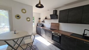 A modern kitchen with dark cabinets, a wooden countertop, and a black pendant light. - "Charming 3-Bedroom Cottage with Jacuzzi, Near Loire and Forest, Ouzouer-sur-Loire" (Ouzouer-sur-Loire)