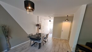 A modern dining area with a glass table, chairs, and a chandelier. - "Charming 3-Bedroom Cottage with Jacuzzi, Near Loire and Forest, Ouzouer-sur-Loire" (Ouzouer-sur-Loire)