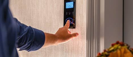 A hand pressing a digital elevator button with the number 605 on it.