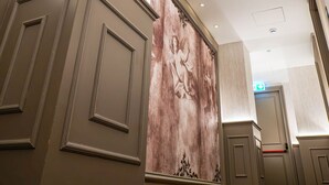 A hotel corridor with a modern design, featuring recessed lighting and a large decorative wall. - Gate Twenty Two Boutique Hotel (Nicosia)