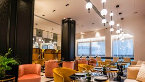A modern hotel lobby with plush seating, a large mirror, and a chandelier. - Gate Twenty Two Boutique Hotel (Nicosia)