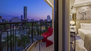 A hotel room with a balcony overlooking a cityscape at dusk. - Gate Twenty Two Boutique Hotel (Nicosia)