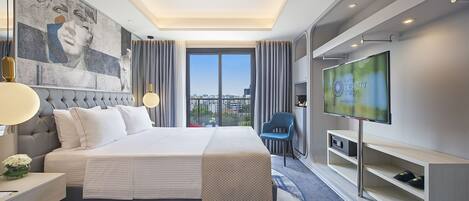 Habitación de hotel moderna con una cama grande, un televisor de pantalla plana, un escritorio y vistas a la ciudad.