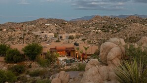 Um resort no deserto com vários edifícios, piscina e terreno rochoso.