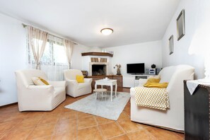 Cozy living space with a fireplace, flat-screen TV, and dining area.