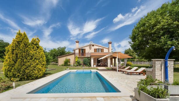 Une maison à deux étages dotée d’une piscine, d’un espace extérieur aménagé et d’un jardin bien entretenu.