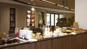 En moderne hotellobby med reception, siddeområde og et stort vindue.
