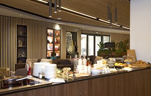 Eine moderne Hotellobby mit Empfangstresen, Sitzgelegenheiten und einem großen Fenster.