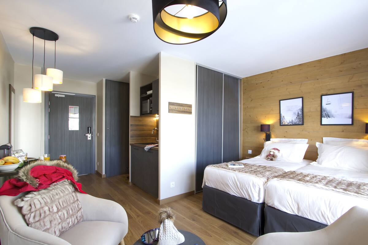 Une chambre d’hôtel avec un mur d’accent en bois, un grand lit, un bureau et une chaise.