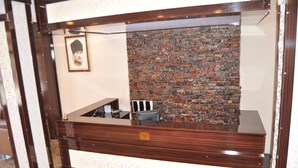 A reception desk with a wooden finish and a patterned design. - Arikan Otel (Pozanti)