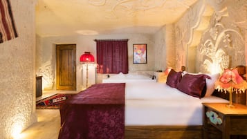 Un dormitorio con una cama grande, una puerta de madera, una lámpara roja y un muro con adornos decorativos.
