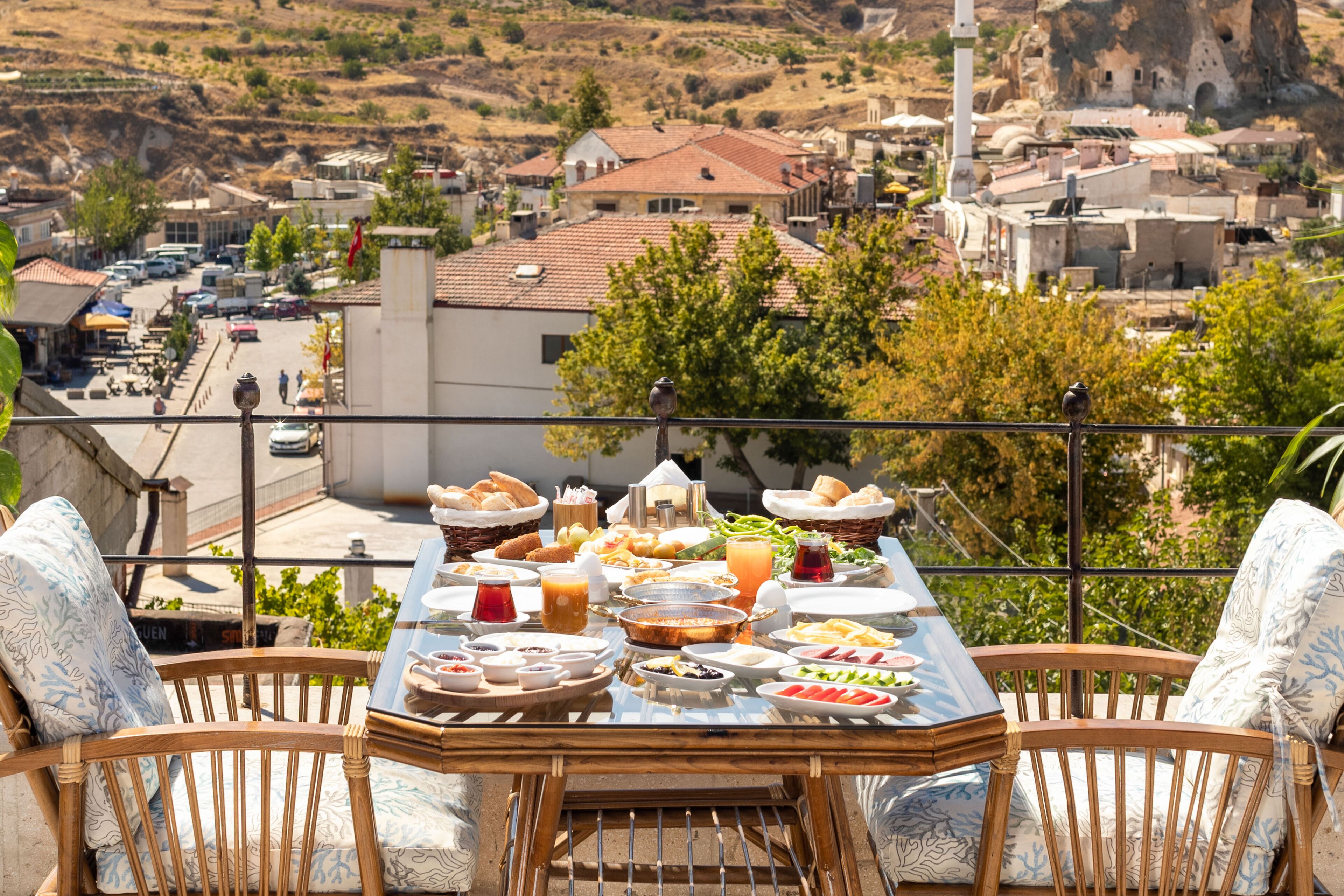 A dining table set with various dishes and a view of a town.