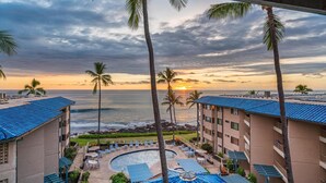 Ein Resort mit Pool, Palmen und Blick auf den Ozean bei Sonnenuntergang.