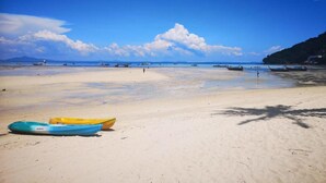 A beach with boats and a clear sky.