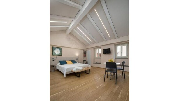Une pièce spacieuse comprenant un lit, un bureau et une chaise.