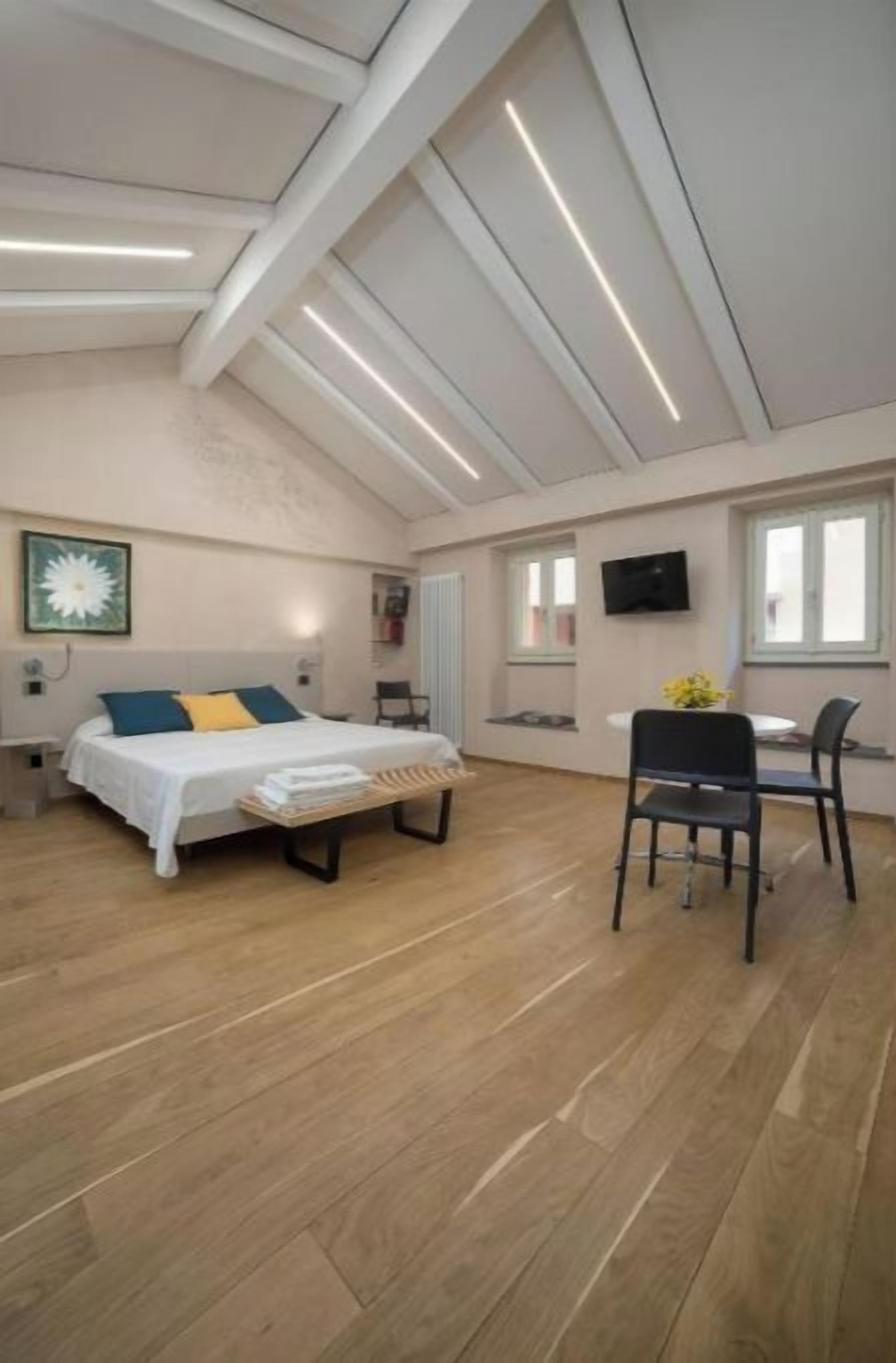 Une pièce spacieuse comprenant un lit, un bureau et une chaise.