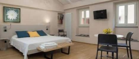 Une pièce spacieuse comprenant un lit, un bureau et une chaise.