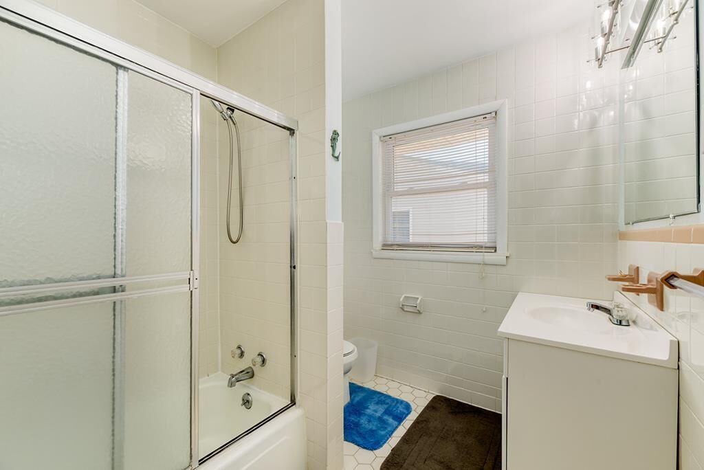 Une salle de bain avec une douche à parois de verre, des toilettes et un lavabo.