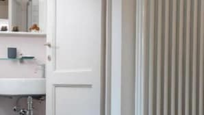 A bathroom with a white door, a mirror, a sink, and a radiator. - Ivana Le Case di Angelina (Farigliano)