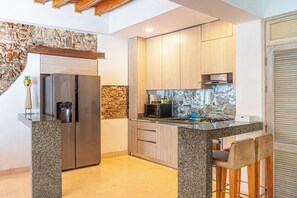 Una cocina moderna con refrigerador integrado, microondas y estufa a gas.