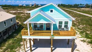 Una casa frente a la playa con balcón, terraza y vista al océano.