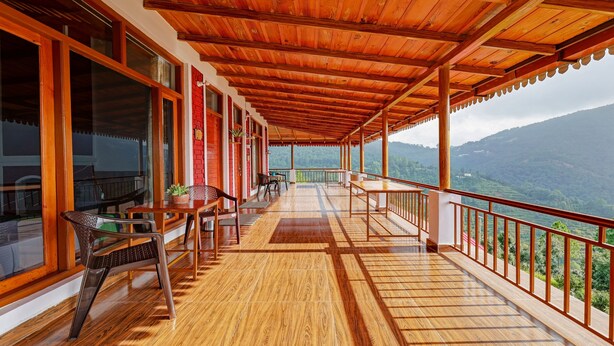 Un balcón de madera con vistas a un paisaje montañoso.