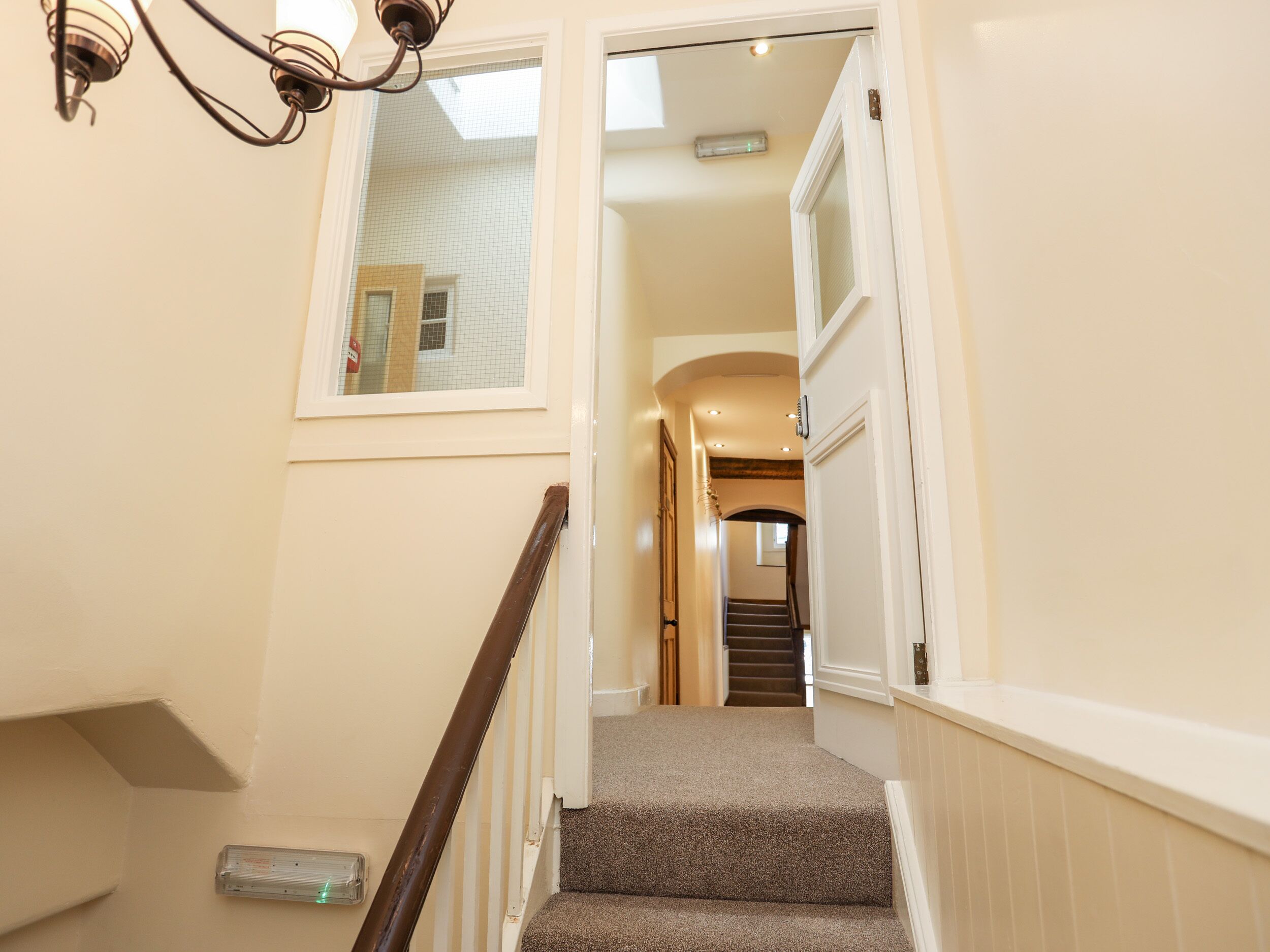 Un escalier avec une rampe en bois menant à un palier.