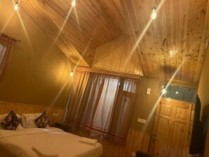 Una habitación con paneles de madera, una cama, cortinas y una puerta.