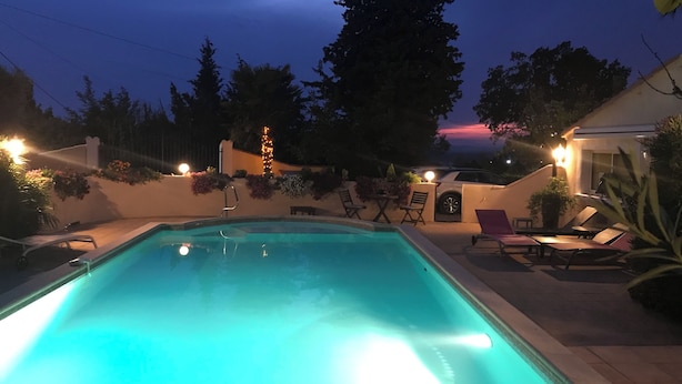 Una piscina con vista al cielo y árboles al atardecer.