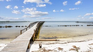 A wooden pier extending into calm waters with clear skies. - Welcome to La Vista! (St. George Island)