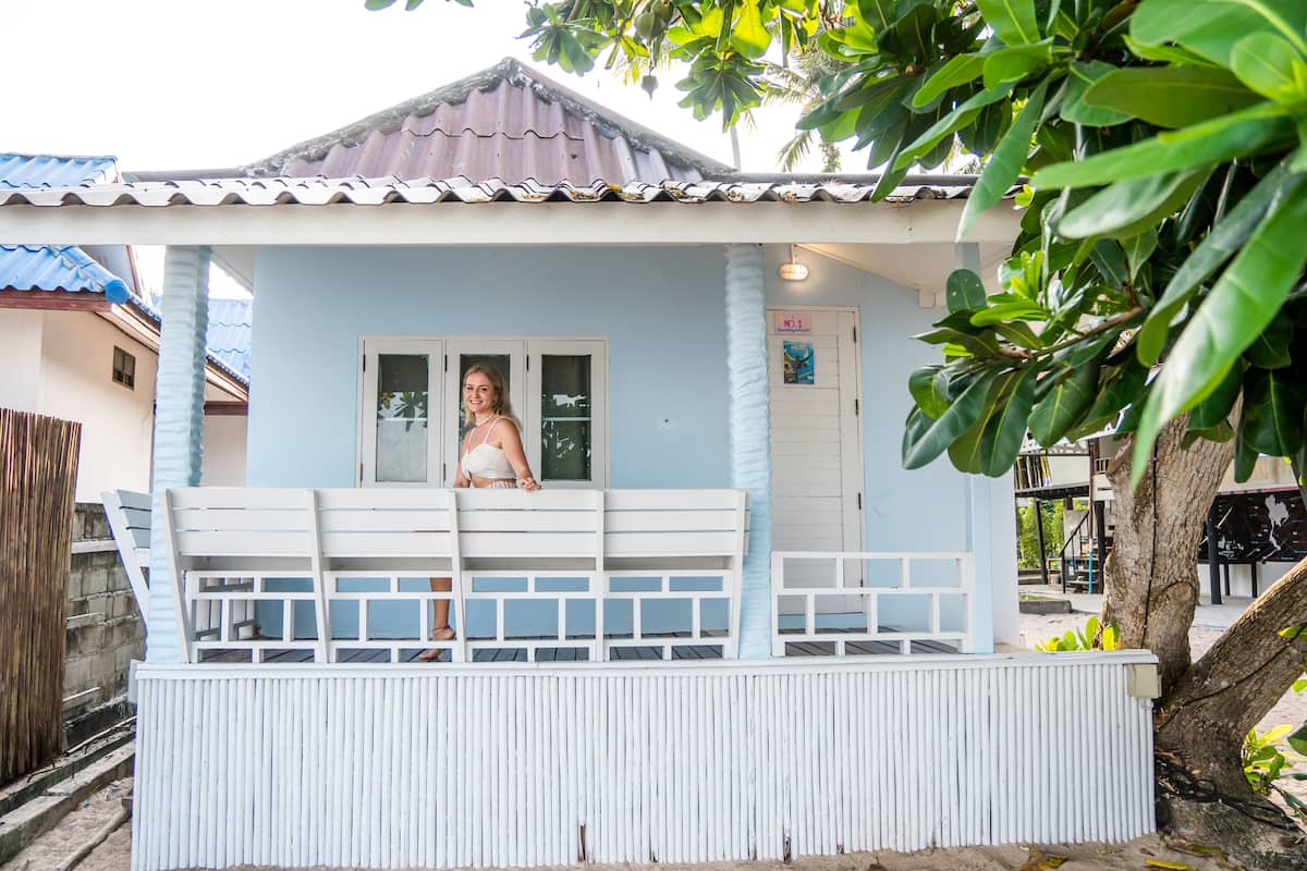 A small, light blue building with a balcony.