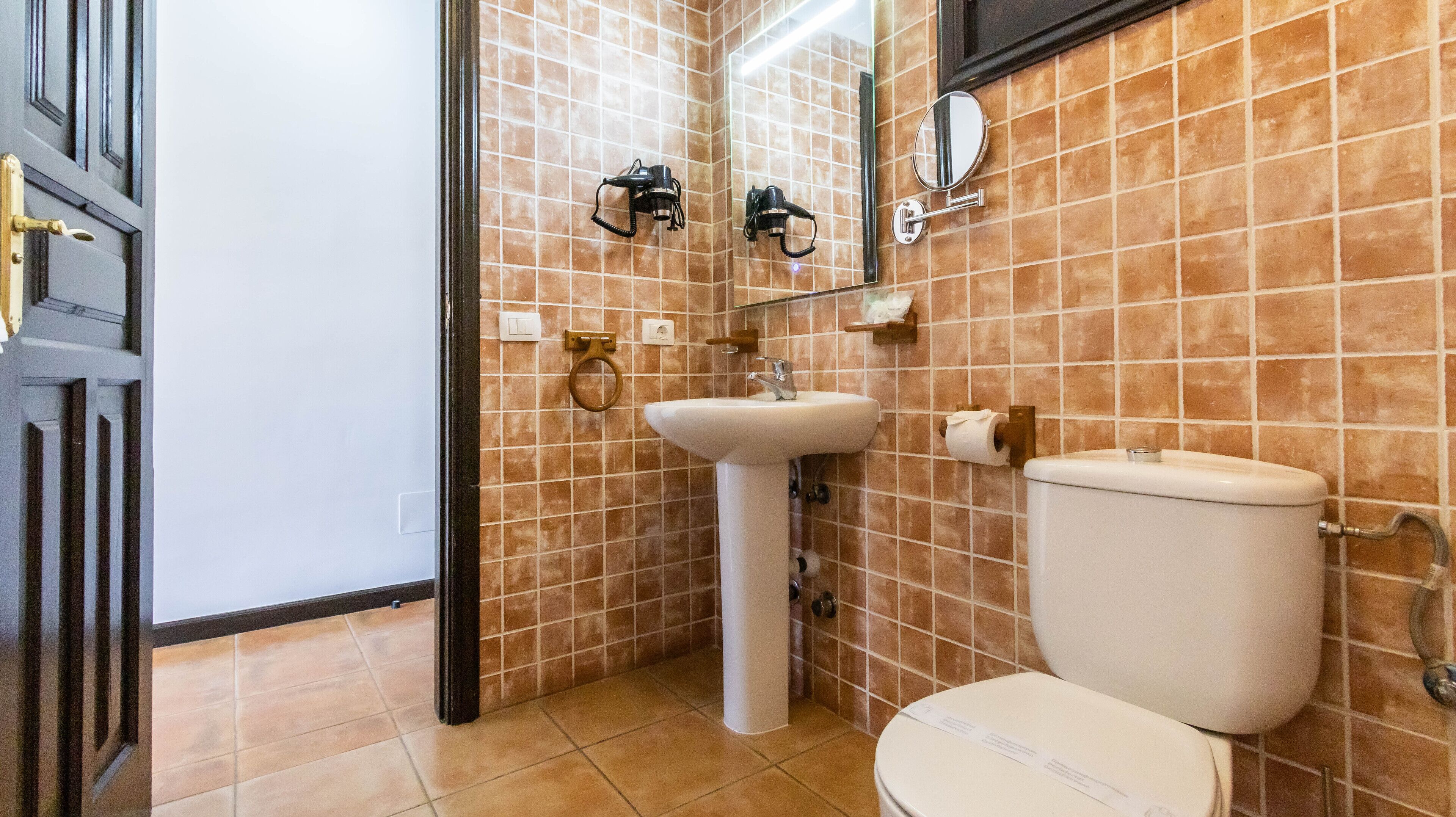 Un baño con un lavamanos blanco, un inodoro y un espejo.