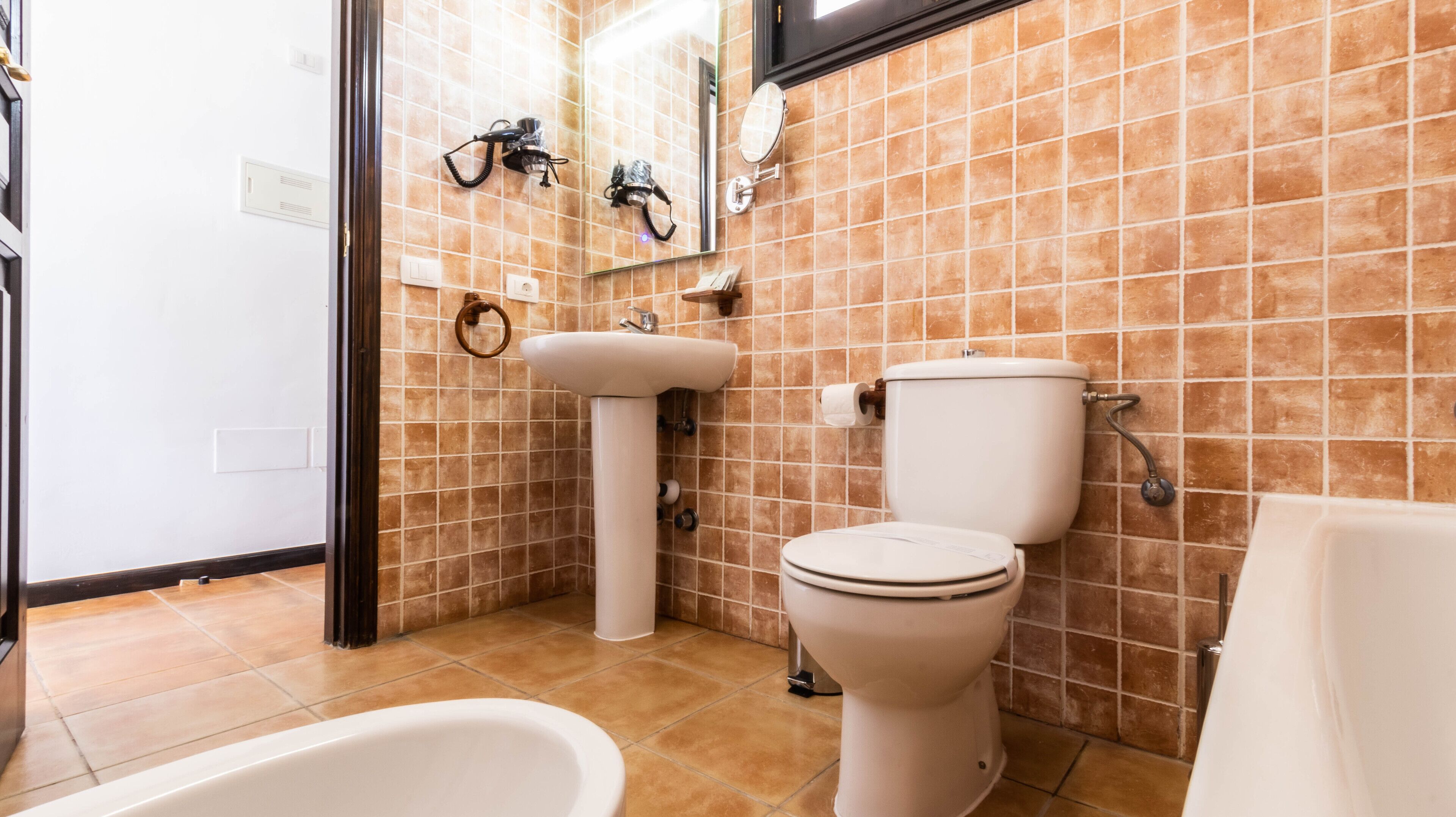 A bathroom with a toilet, sink, and bathtub.