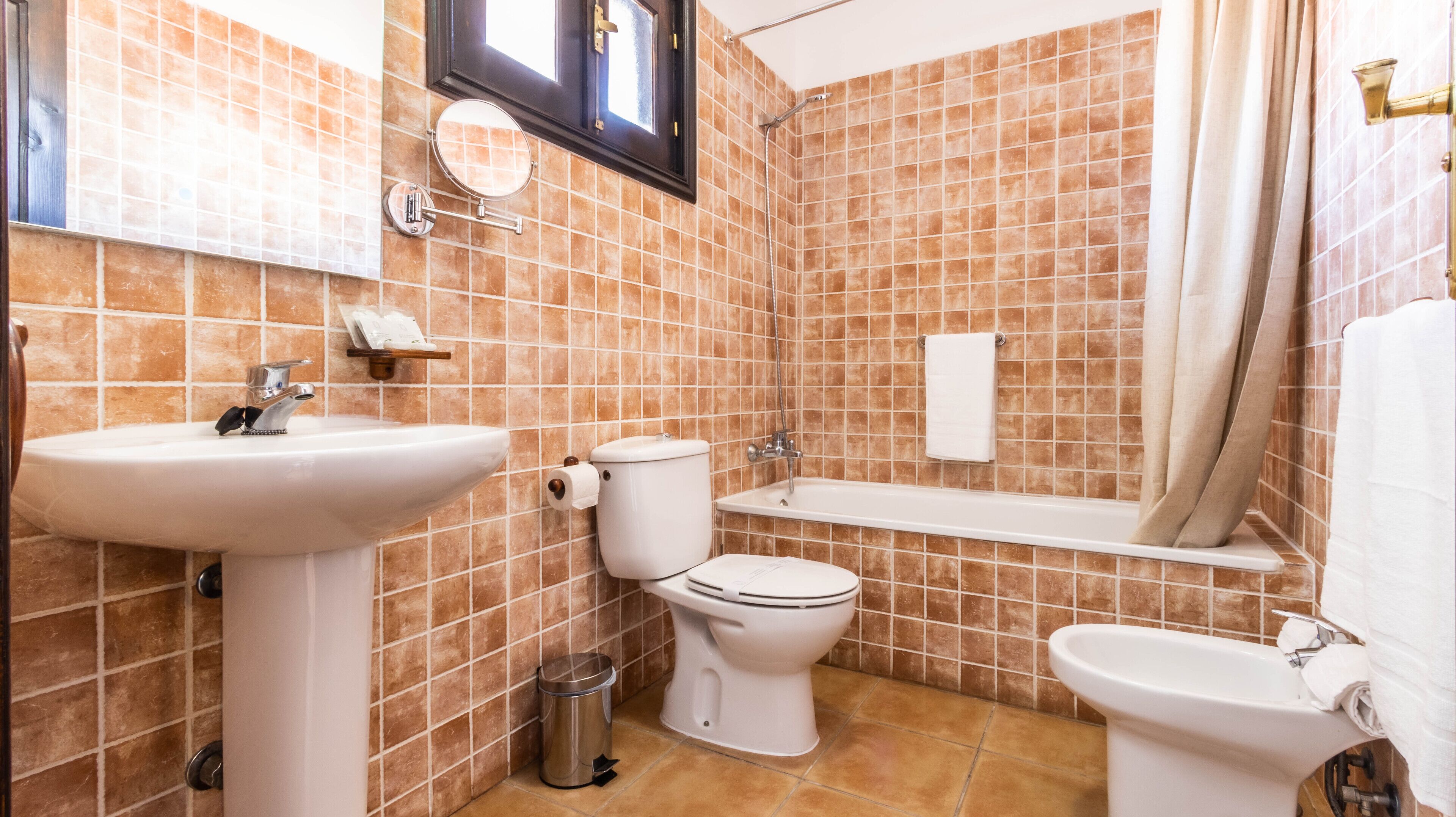 Un baño con lavamanos, inodoro y bañera.