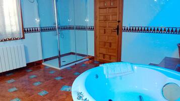 Un baño con ducha de vidrio, puerta de madera y bañera.